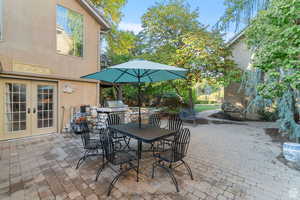 View of patio featuring outdoor dining area, an outdoor kitchen, and french doors