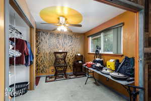 Office with light carpet and ceiling fan