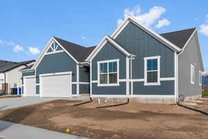 View of front facade with concrete driveway, an attached garage, and a shingled roof