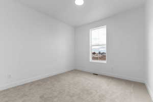 Spare room with light colored carpet and baseboards