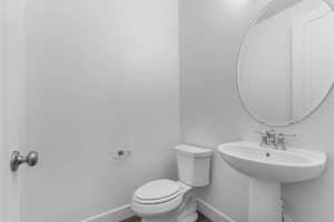 Half bathroom with baseboards and toilet