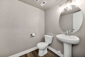 Half bath featuring dark wood-style floors
