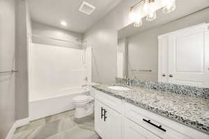 Full bath featuring tub / shower combination, vanity, light tile patterned floors, and recessed lighting