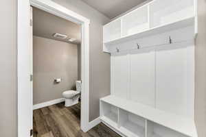 Mudroom featuring dark wood-style flooring and baseboards