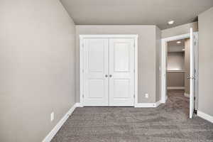 Unfurnished bedroom featuring carpet and a closet