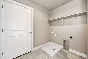 Laundry room featuring tile patterned floors, washer hookup, and electric dryer hookup