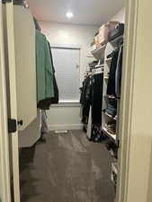 Walk in closet featuring dark colored carpet