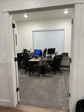 Office area featuring light wood-style floors and recessed lighting