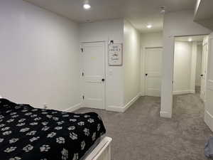 Bedroom with dark colored carpet and recessed lighting