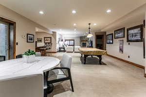 Playroom with a stone fireplace, recessed lighting, light colored carpet, and billiards table