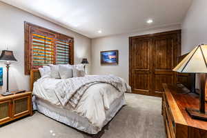 Bedroom with light carpet and recessed lighting