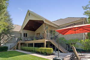 Rear view of property featuring stairway, a yard, brick siding, and a wooden deck