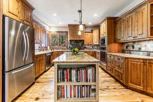 Kitchen featuring open shelves, brown cabinets, appliances with stainless steel finishes, and recessed lighting