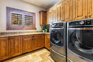 Laundry area with separate washer and dryer and cabinet space