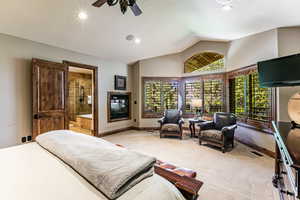 Bedroom with lofted ceiling, recessed lighting, carpet floors, ceiling fan, and ensuite bathroom