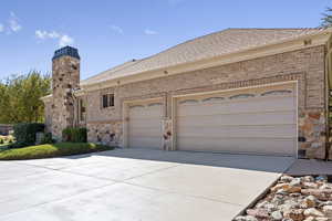 Ranch-style home featuring concrete driveway, brick siding, roof with shingles, and a garage