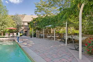 Outdoor pool with stairs, a patio, a balcony, and outdoor dining space