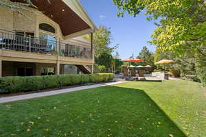 View of grassy yard with a patio area and stairway