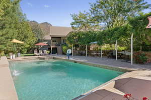 View of pool with a patio and a mountain view