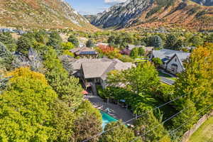 Aerial view of residential area featuring a mountainous background and a tree filled landscape