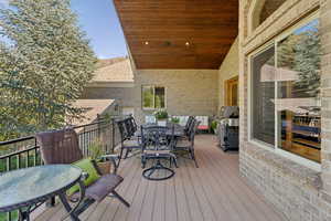 Deck with outdoor dining space and a grill