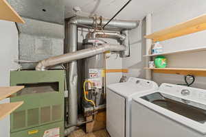 Laundry area with water heater, heating unit, and washer and clothes dryer