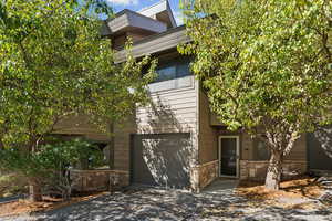 Modern home featuring stone siding and an attached garage