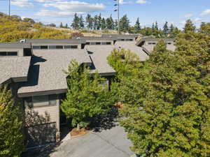 View of subject property with a tree filled landscape