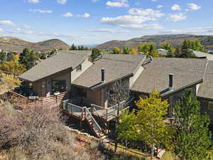 Back of house featuring a deck with mountain view and a shingled roof