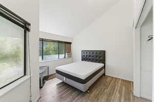 Bedroom with lofted ceiling and wood finished floors