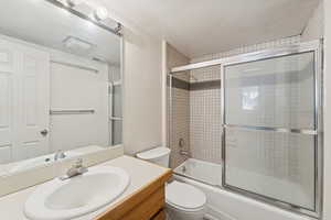 Bathroom featuring vanity and enclosed tub / shower combo