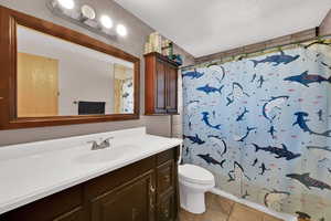 Bathroom featuring light tile patterned floors, vanity, and a shower stall