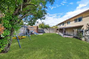 Fenced backyard with a shed and a playground
