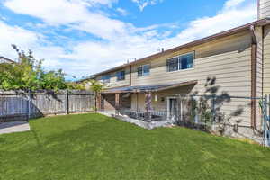 Back of house with a fenced backyard and a patio