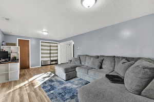 Living area featuring light wood-type flooring and a textured ceiling