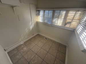Spare room featuring tile patterned floors and baseboards