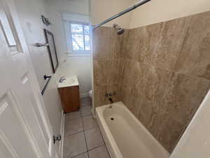 Full bath with vanity, light tile patterned floors, and washtub / shower combination