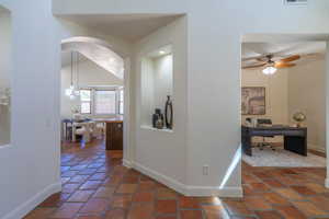Hallway featuring a desk and arched walkways