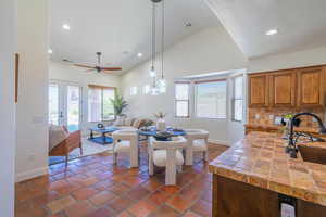 Kitchen with plenty of natural light, brown cabinets, recessed lighting, tasteful backsplash, and decorative light fixtures