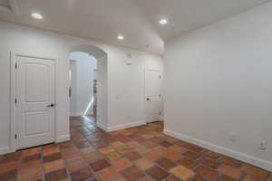 Empty room featuring arched walkways and recessed lighting