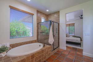 Bathroom with a bath, a shower stall, recessed lighting, ensuite bath, and dark tile patterned flooring