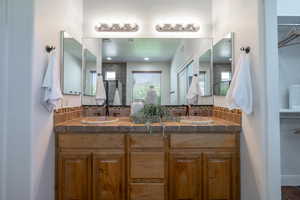 Bathroom with a shower stall, double vanity, and decorative backsplash