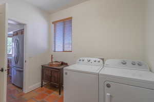 Laundry area featuring washing machine and dryer and baseboards