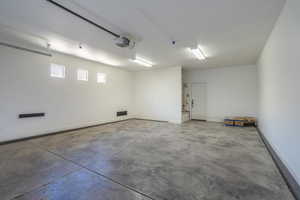 Garage featuring baseboards and a garage door opener