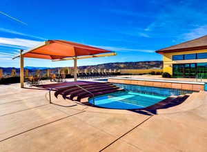 Community pool featuring a mountain view, a hot tub, and a patio