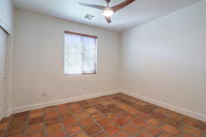 Unfurnished room featuring ceiling fan and baseboards