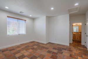 Empty room featuring recessed lighting, attic access, and a textured ceiling