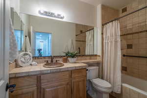 Full bath featuring tiled shower / bath combo, vanity, and backsplash