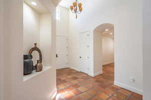 Entryway with recessed lighting, arched walkways, and a towering ceiling