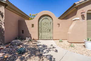 View of exterior entry with stucco siding and a tiled roof